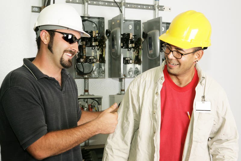 Electrical foreman giving a worker the thumbs-up. Models are actual electricians. Electrical foreman giving a worker the thumbs-up. Models are actual electricians.