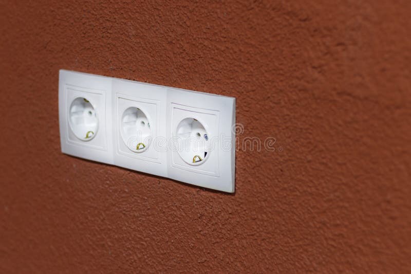 Elektriciteitscontactdoos Witte kleur Oranje Achtergrond Ondiepe Diepte van Gebied op het nest worden er gewreven weg van het geb royalty-vrije stock afbeeldingen Elektriciteitscontactdoos Witte kleur Oranje Achtergrond Ondiepe Diepte van Gebied op het nest worden er gewreven weg van het geb royalty-vrije stock afbeeldingen