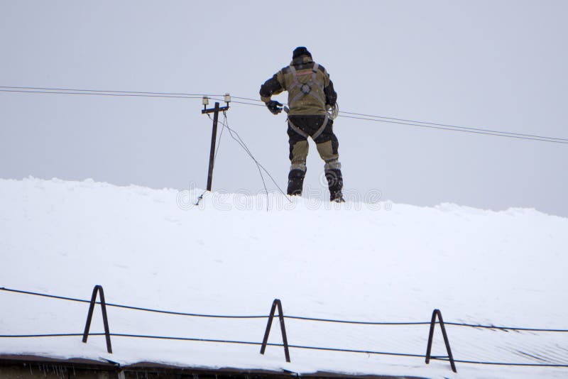 Elektriker, der auf Spitzendach steht und beim Denken weg schaut Hintere Ansicht des Bauarbeiters den Schutzhelm halten, der a sc stockfotografie Elektriker, der auf Spitzendach steht und beim Denken weg schaut Hintere Ansicht des Bauarbeiters den Schutzhelm halten, der a sc stockfotografie