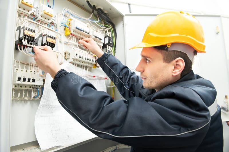 Elektriker mit dem Zeichnen an der Stromleitung Kasten lizenzfreies stockbild Elektriker mit dem Zeichnen an der Stromleitung Kasten lizenzfreies stockbild