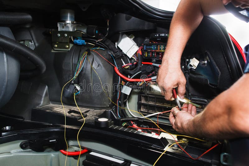 Elektrikeren arbetar med det elektriska kvarteret i bil arkivfoton Elektrikeren arbetar med det elektriska kvarteret i bil arkivfoton