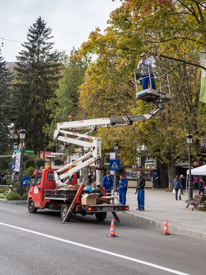 Elektrikeren reparerar gatabelysning på boulevarden av lovsången första i Sinaia i Rumänien royaltyfri bild Elektrikeren reparerar gatabelysning på boulevarden av lovsången första i Sinaia i Rumänien royaltyfri bild