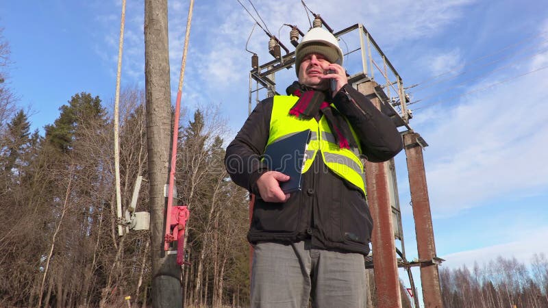 Elektrikeringenieur, der intelligentes Telefon am Transformator verwendet stock footage