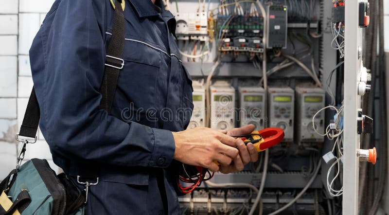 Elektrikeringenjör kontrollerar strömkretsen i kontrollpanelen för start och idriftsättning av högström och spänning