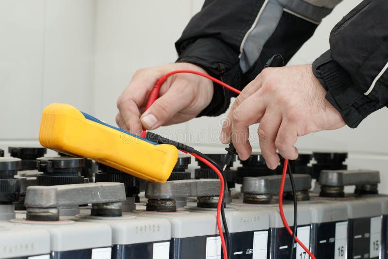 Elektrikerkontrollbatteri med den gula multimeteren royaltyfri foto Elektrikerkontrollbatteri med den gula multimeteren royaltyfri foto