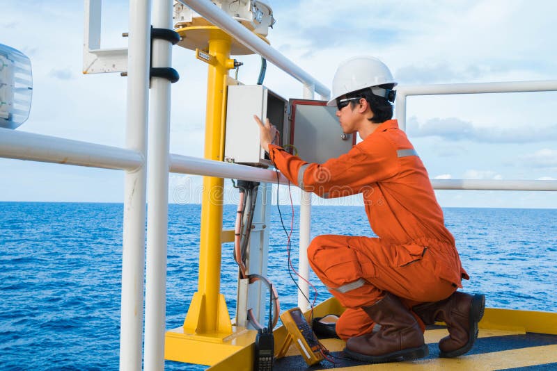 Elektrischer und Instrument-Techniker ist Inspektion auf Beleuchtung der Navigationsbeihilferegelung an der Öl- und Gashauptquell stockbild Elektrischer und Instrument-Techniker ist Inspektion auf Beleuchtung der Navigationsbeihilferegelung an der Öl- und Gashauptquell stockbild