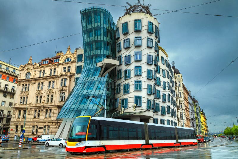 Elektrisk röd spårväg och berömt danshus i bakgrund, Prague royaltyfri bild