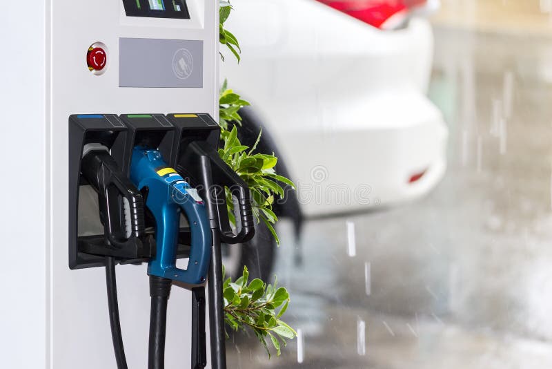 Electric vehicle charging Ev station and plug of power cable supply for Ev car with raining day background. Electric vehicle charging Ev station and plug of power cable supply for Ev car with raining day background.