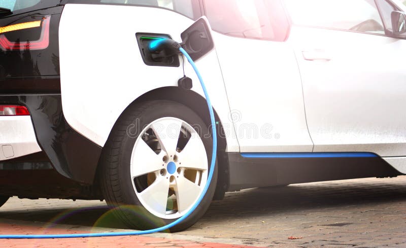 Elektroauto, das mit einem Ladegerätsockel auflädt stockfotografie Elektroauto, das mit einem Ladegerätsockel auflädt stockfotografie