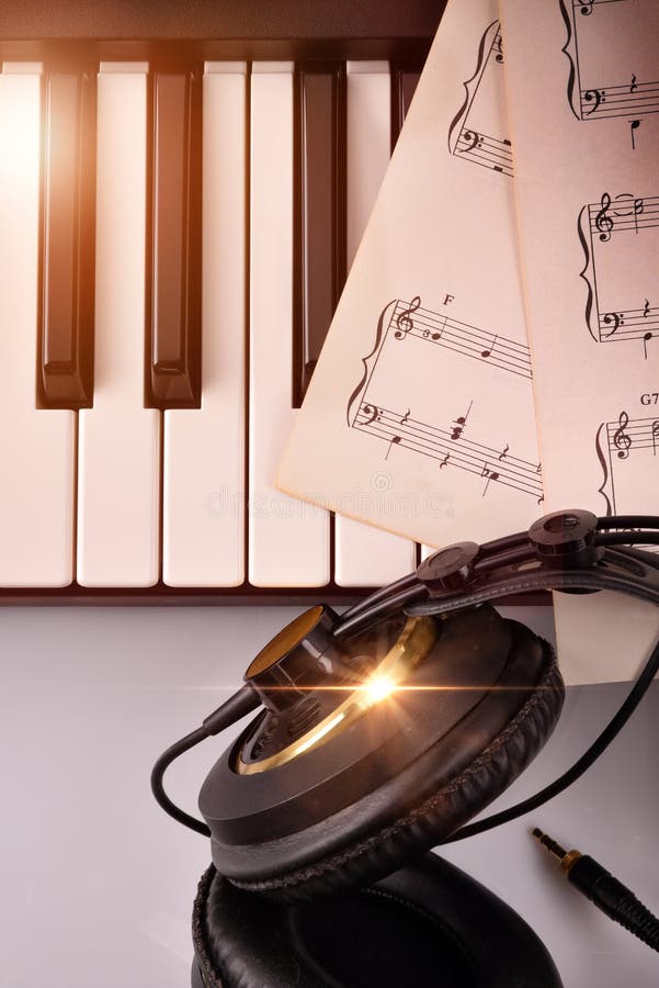 Elektronisch pianotoetsenbord met hoofdtelefoons en de bovenkant van de bladmuziek stock afbeelding Elektronisch pianotoetsenbord met hoofdtelefoons en de bovenkant van de bladmuziek stock afbeelding
