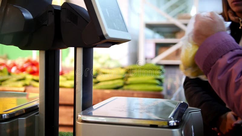 Elektronische Skalen im Supermarkt, Kunde wiegt die Frucht in der Gemüseabteilung