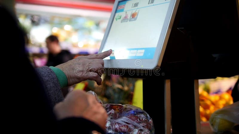 Elektronische Skalen im Supermarkt, Kunden - zwei alte Damen wiegt die Trauben in der Gemüseabteilung