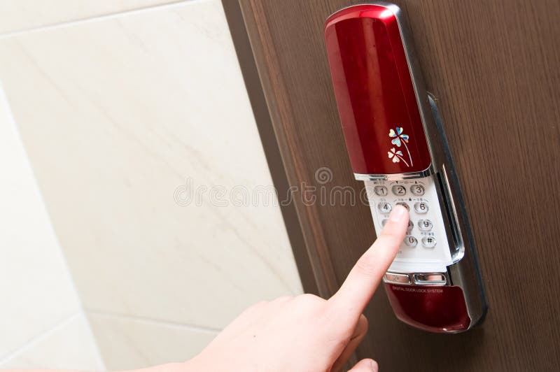 Hand entering the PIN code with the keypad of modern electronic door lock with sliding cover. Hand entering the PIN code with the keypad of modern electronic door lock with sliding cover.