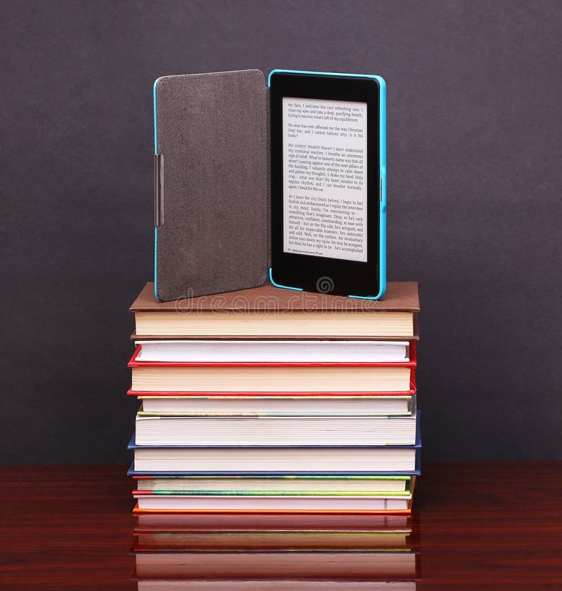 Elektronischer Buchleser und alte Bücher des Stapels auf hölzernem Schreibtisch stockbild Elektronischer Buchleser und alte Bücher des Stapels auf hölzernem Schreibtisch stockbild
