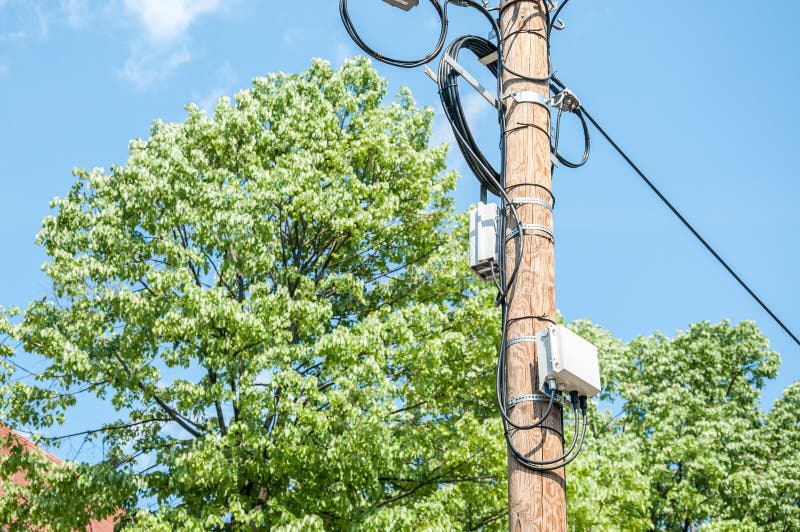Elektryczni druty na drewnianym ulicznym słupie z komunikacyjnymi pudełkami i niebieskiego nieba tłem interneta lub telefonu komó zdjęcie royalty free Elektryczni druty na drewnianym ulicznym słupie z komunikacyjnymi pudełkami i niebieskiego nieba tłem interneta lub telefonu komó zdjęcie royalty free