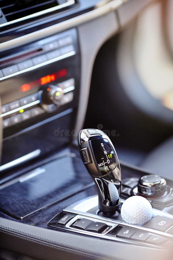 Element of modern luxury car interior automatic transmission shift lever with mode buttons with golf ball lying next to it stock photo Element of modern luxury car interior automatic transmission shift lever with mode buttons with golf ball lying next to it stock photo