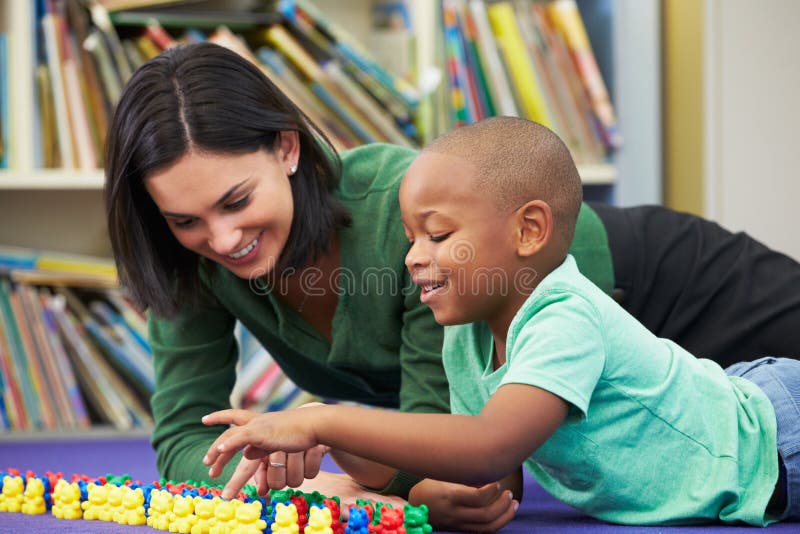 Elementary Pupil Counting With Teacher In Classroom royalty free stock image