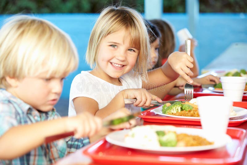 Elementary Pupils Enjoying Healthy Lunch In Cafeteria stock photos