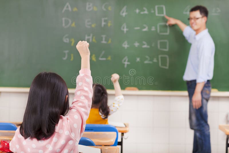 Elementary school students raising hands royalty free stock image