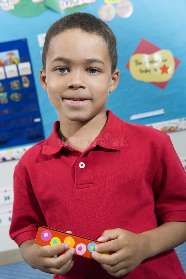 Portrait of a little boy holding harmonica in classroom. Portrait of a little boy holding harmonica in classroom