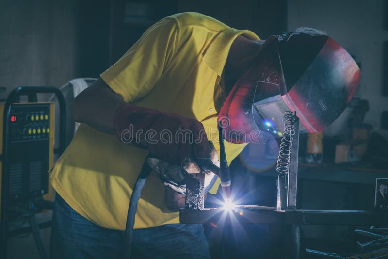 Elementi d'acciaio di saldatura alla fabbrica o all'officina fotografie stock libere da diritti Elementi d'acciaio di saldatura alla fabbrica o all'officina fotografie stock libere da diritti