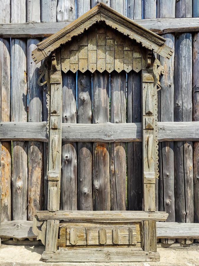 Elementos tallados de la arquitectura de madera rusa. Sobre el fondo de una antigua valla de madera ahumada y gris. Sobre el fondo de una antigua valla hecha de troncos de madera maderables y gris. Copiar espacio para el texto.