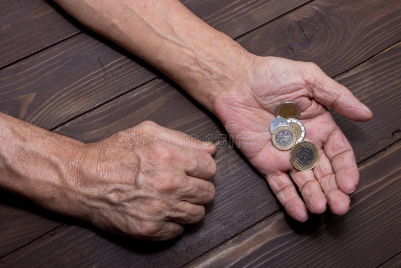 Elemosinando i soldi Mani anziane della persona del mendicante con poche monete Il concetto di povertà fotografia stock Elemosinando i soldi Mani anziane della persona del mendicante con poche monete Il concetto di povertà fotografia stock