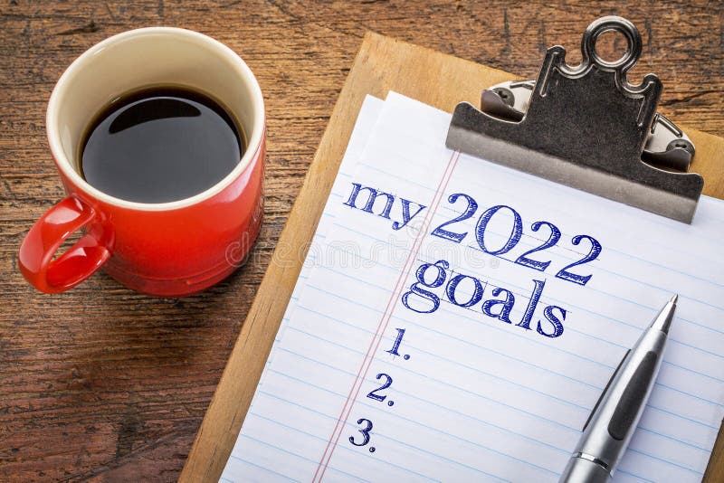 My 2022 goals list on clipboard and coffee against grunge wood desk, setting New Year goals and resolutions. My 2022 goals list on clipboard and coffee against grunge wood desk, setting New Year goals and resolutions