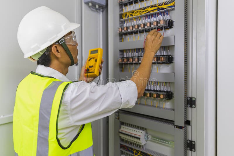 Elettricista che installa cavi elettrici e commutatore a fusibile. multimetro in mano agli elettricisti - dettagli fotografia stock libera da diritti