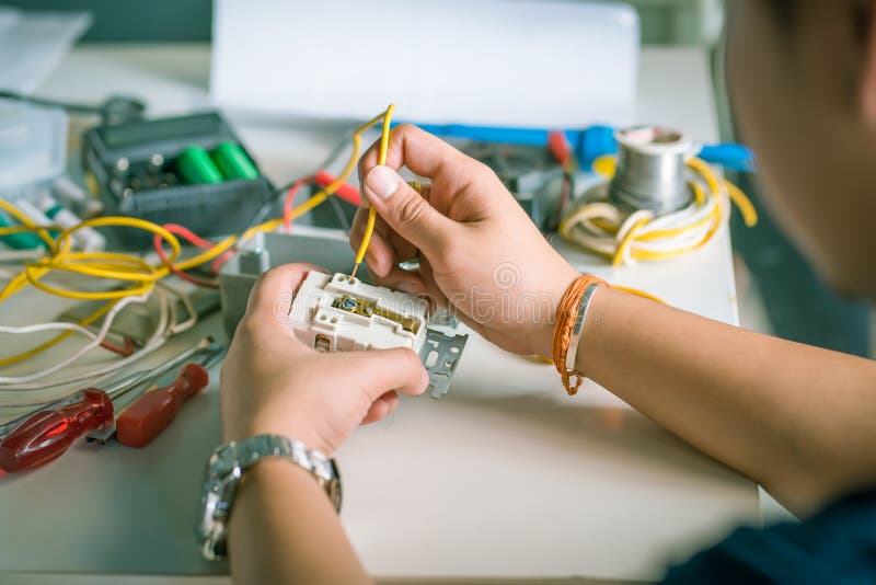 Elettricista che installa zoccolo chiuda su di spirito delle mani dell'elettricista immagine stock Elettricista che installa zoccolo chiuda su di spirito delle mani dell'elettricista immagine stock