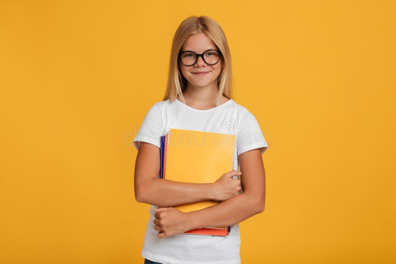 Elev alb fericit adolescent alb în tricou alb și ochelari ține cărți royalty free stock photography