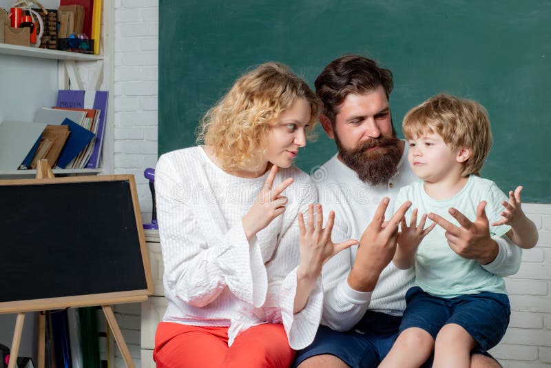 Elev som lär bokstäver och nummer - matematikbegrepp Unga par som hjälper hans son att göra läxa l?ra och arkivbilder Elev som lär bokstäver och nummer - matematikbegrepp Unga par som hjälper hans son att göra läxa l?ra och arkivbilder