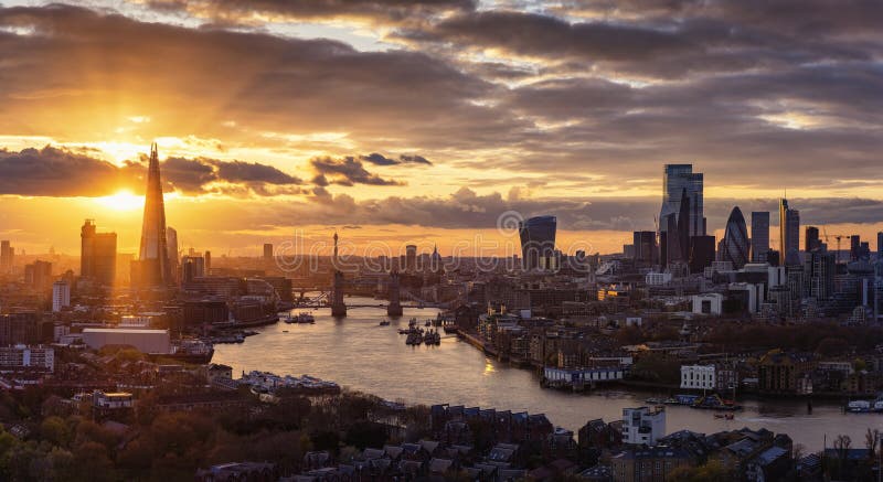 Elevated, panoramic view to the modern skyline of London from the Tower Bridge to the skyscrapers of the City during a colorful sunset, United Kingdom. Elevated, panoramic view to the modern skyline of London from the Tower Bridge to the skyscrapers of the City during a colorful sunset, United Kingdom