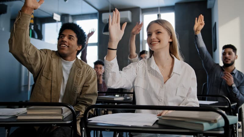 Elevi inteligenți din diferite grupuri care stau în clasă la lecție și ascultă cu atenție prelegerea profesorilor la școală sau royalty free stock photos