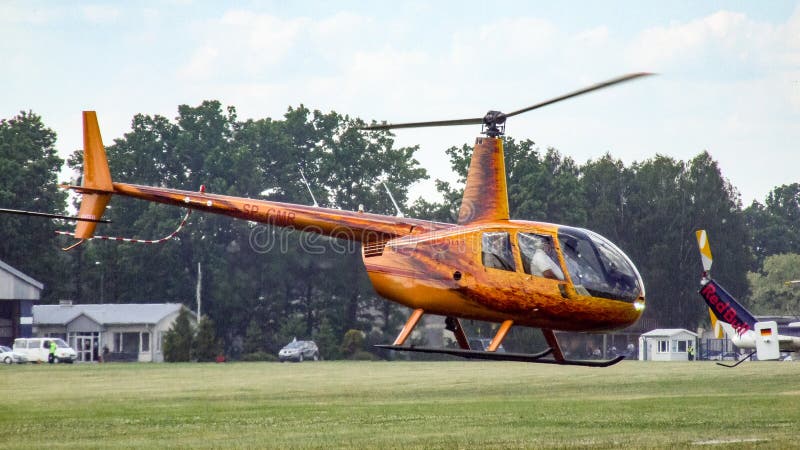 Elicottero del pistone di Robinson R44 che decolla in Goraszka in Polonia immagine stock Elicottero del pistone di Robinson R44 che decolla in Goraszka in Polonia immagine stock
