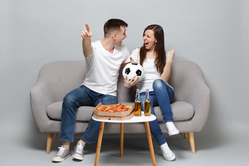 Elogio alegre dos fan de futebol do homem da mulher dos pares acima da equipe favorita do apoio com bola de futebol, mãos gesticu fotografia de stock Elogio alegre dos fan de futebol do homem da mulher dos pares acima da equipe favorita do apoio com bola de futebol, mãos gesticu fotografia de stock