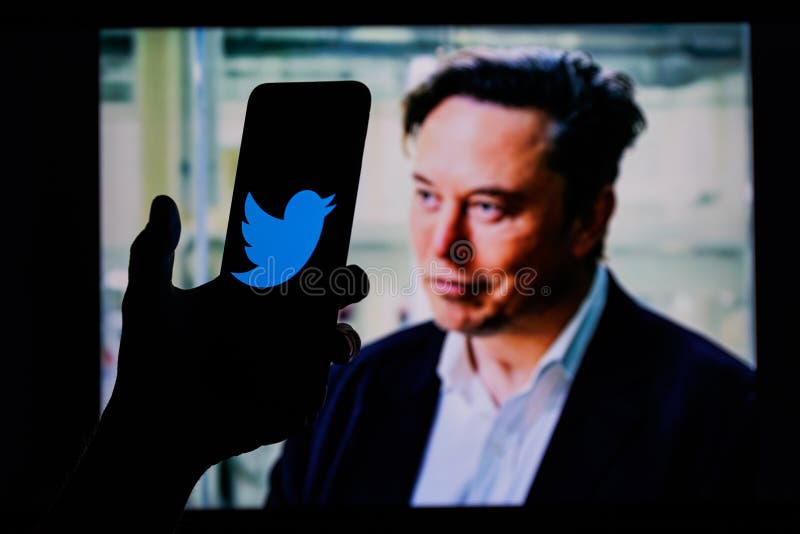 Elon Musk twitter account on mobile phone screen. Twitter logo in background