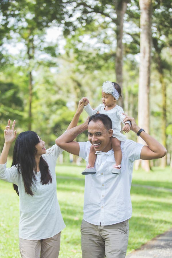 Eltern in der weißen Kleidung gehend mit ihrer Babytochter in lizenzfreie stockfotografie Eltern in der weißen Kleidung gehend mit ihrer Babytochter in lizenzfreie stockfotografie