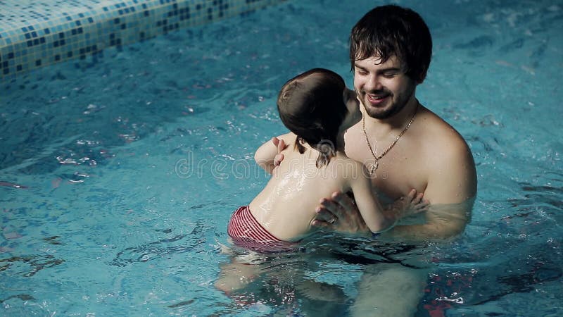 Eltern, die ihren Sohn unterrichten, im Pool zu schwimmen