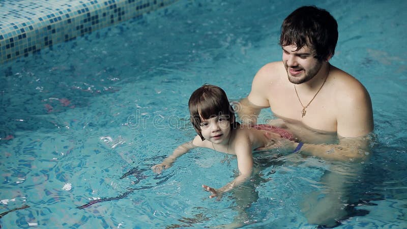 Eltern, die ihren Sohn unterrichten, im Pool zu schwimmen