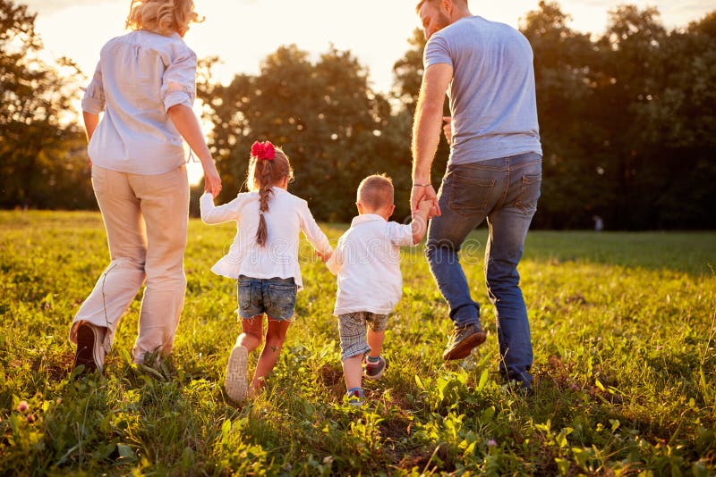 Eltern mit den Kindern, die in Natur, hintere Ansicht gehen lizenzfreies stockfoto Eltern mit den Kindern, die in Natur, hintere Ansicht gehen lizenzfreies stockfoto