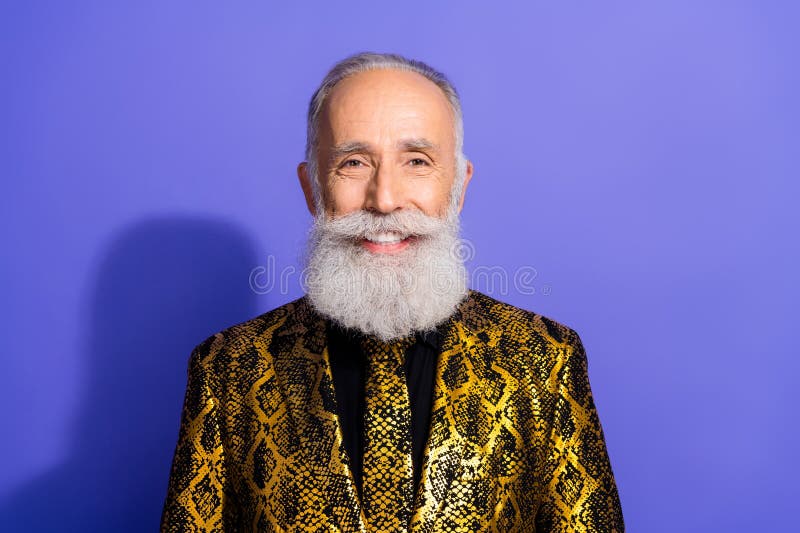 Elégant homme âgé avec une veste d'or stylisée posant en toute confiance sur un fond violet images stock