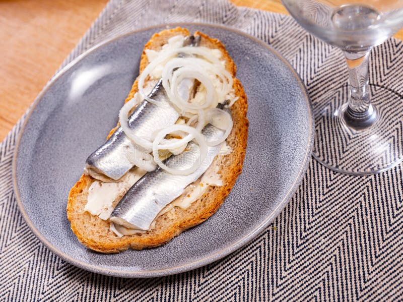 On top of greased bread is slices of lightly salted herring. Sandwich with butter and fish, decorated with ring of garden onion. On top of greased bread is slices of lightly salted herring. Sandwich with butter and fish, decorated with ring of garden onion