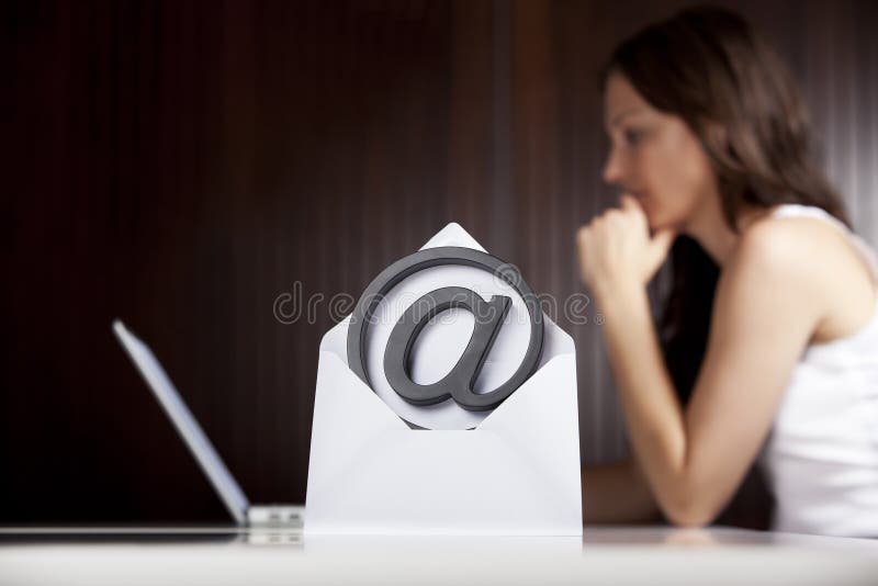 Emailing concept: At letter with woman and laptop.