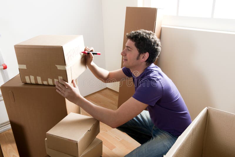 Young man packing boxes at home. Young man packing boxes at home