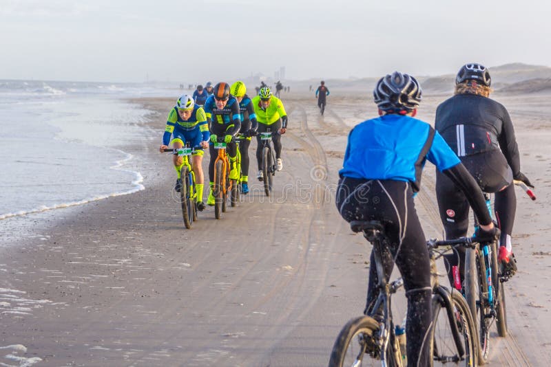 Emballage des cavaliers de concurrence de vélo en plage photos libres de droits Emballage des cavaliers de concurrence de vélo en plage photos libres de droits