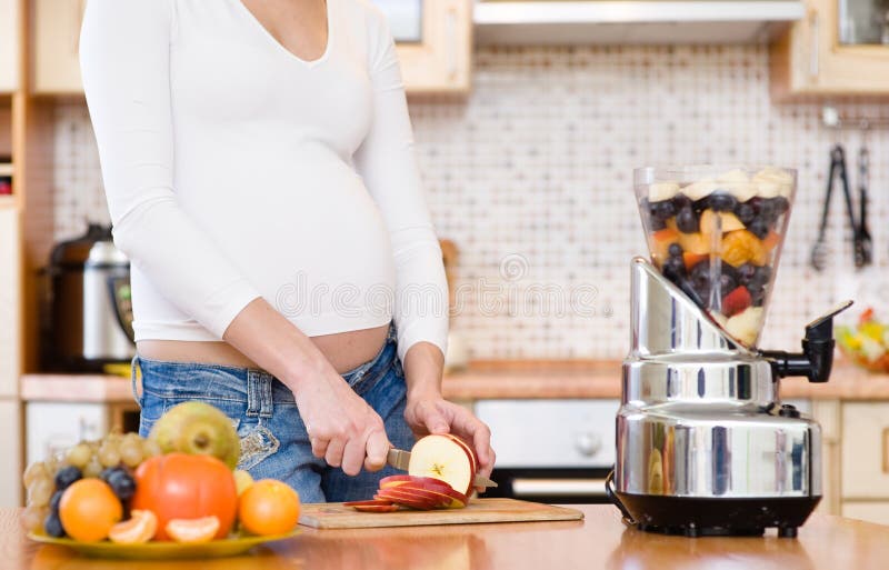 Embarazo y nutrición - mujer embarazada con las frutas fotos de archivo libres de regalías Embarazo y nutrición - mujer embarazada con las frutas fotos de archivo libres de regalías