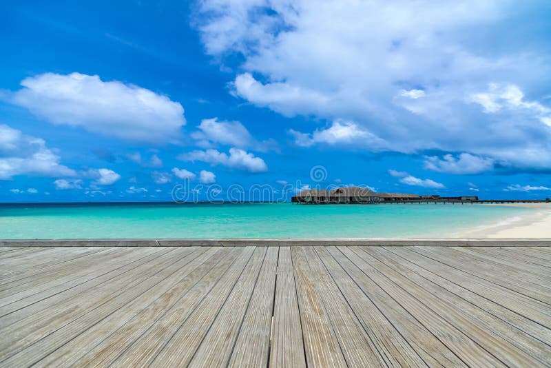 Embarcadero gris de madera en la playa perfecta en día soleado con el cielo azul