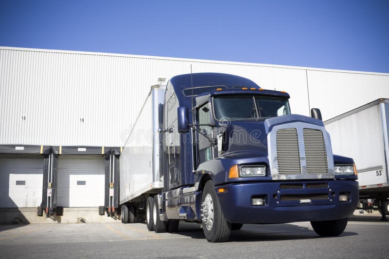 Blue Transport Truck Docking in yard from an extreme low angle view. Blue Transport Truck Docking in yard from an extreme low angle view