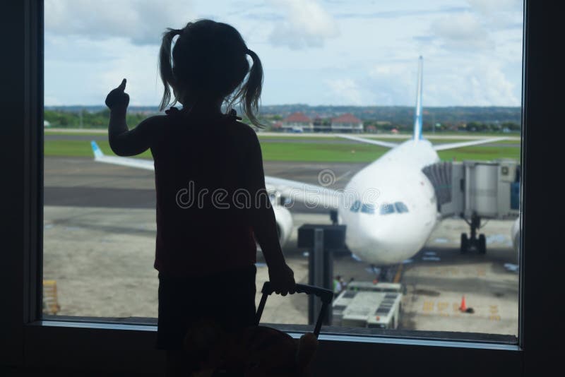 Embarque de espera da criança pequena a migrar no terminal de aeroporto fotografia de stock Embarque de espera da criança pequena a migrar no terminal de aeroporto fotografia de stock
